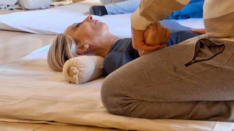 Un operatore tiene con una mano il polso di una donna bionda l'altra mano è posizionata sul tanden.